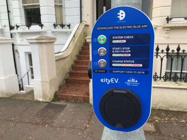 A picture of an electric vehicle charger in front of some terraced houses