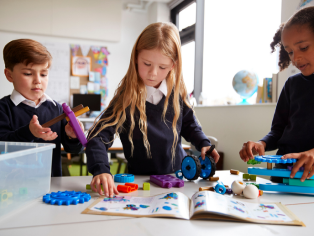 children in a classroom working with coloured shapes