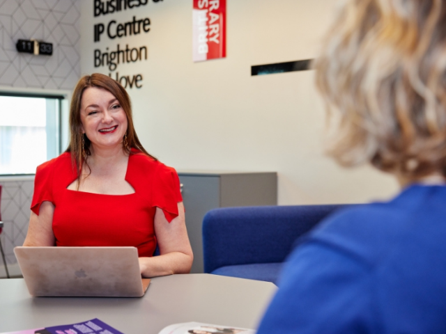 Claire Mason, ambassador and entrepreneur in residence for BIPC Sussex, talking to a colleague in the BIPC Centre in Jubilee Library, Brighton