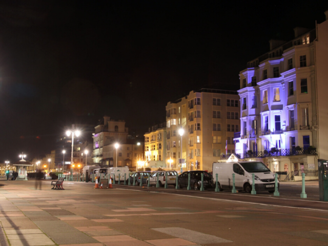 Photo showing a well lit section Brighton & Hove seafront at night