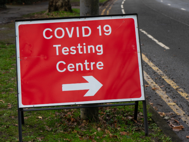 Photo of a red road sign saying COVID-19 Testing Centre