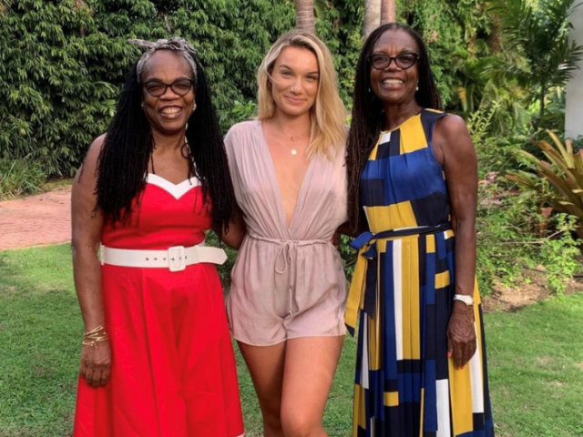 Young woman poses with her foster mum and her foster aunt in a garden.