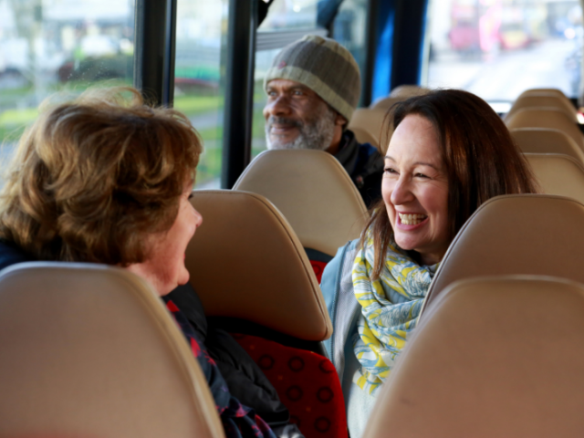 Three people sitting on a bus