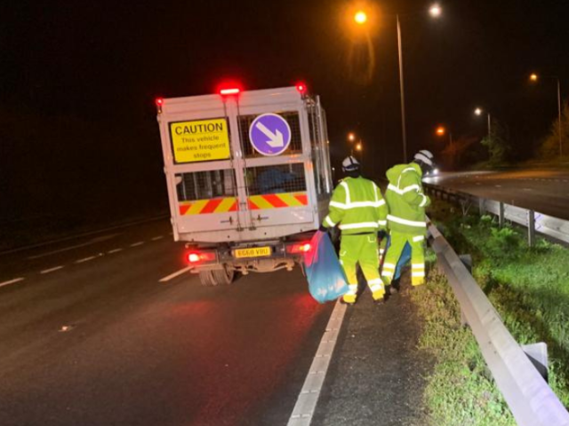 Truck in front of operatives litter picking grass verge of road