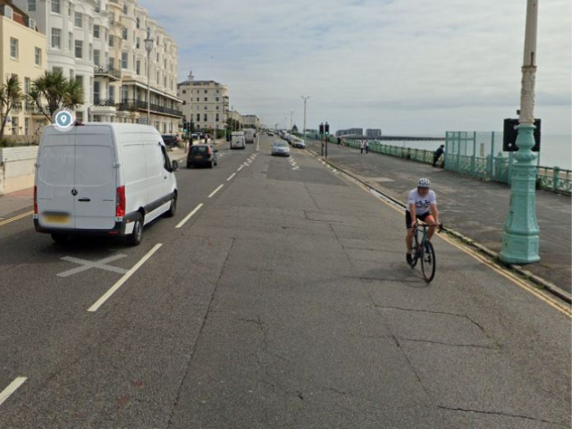 A picture of a road with a white van and a cyclist
