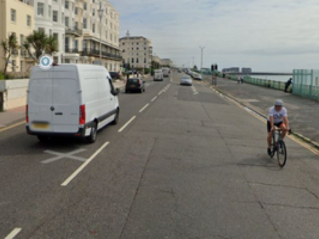 A picture of a road with a white van and a cyclist