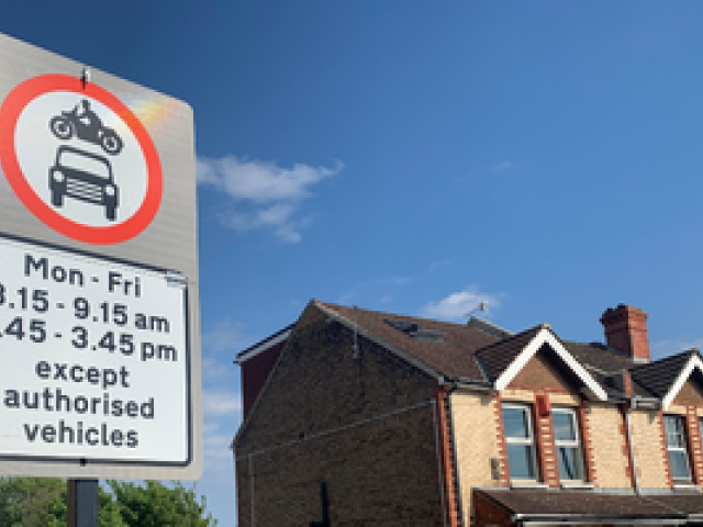 A picture of a road sign next to some houses