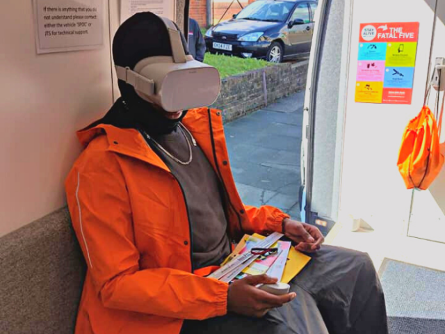 A man sitting down wearing a virtual reality headset