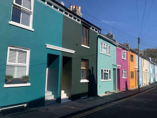 A terrace of sunlight brightly painted houses