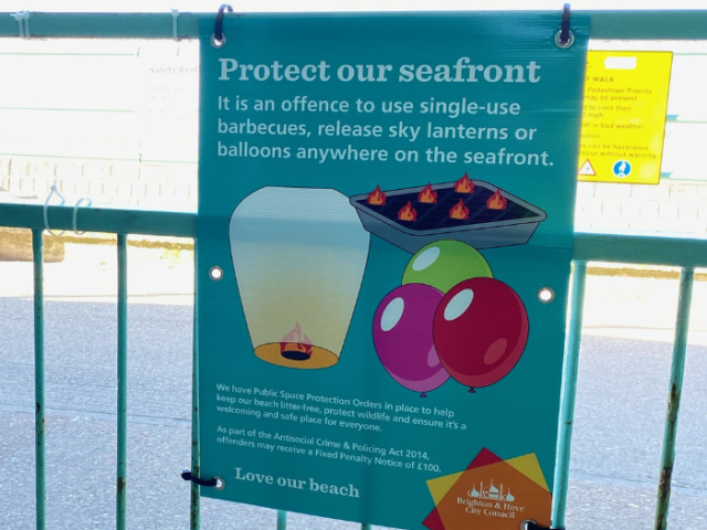 Photo of a colourful sign on Brighton & Hove seafront outlining the restrictions on using disposable barbecues and releasing lanterns and balloons