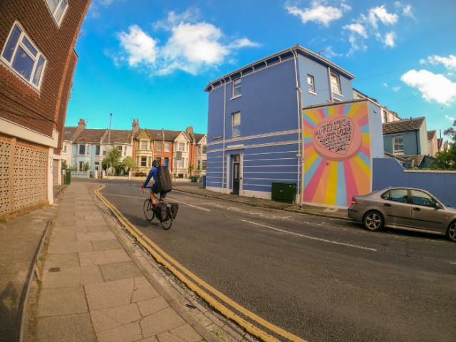 A cyclist on a road with houses