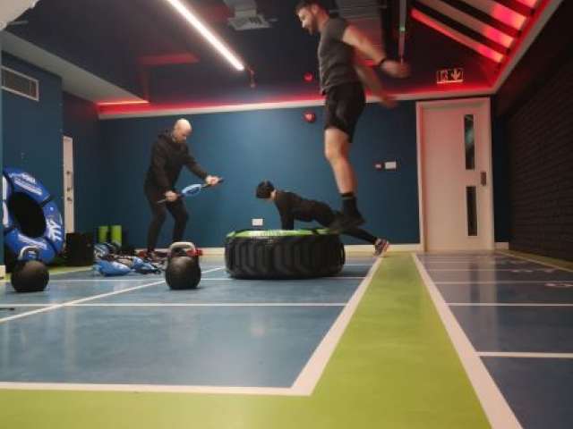 Three people using exercise equipment in a leisure centre studio