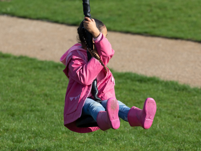 Child playing on swing in park