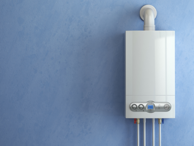 The boiler has four pipes leading from the underside. The wall is otherwise empty.