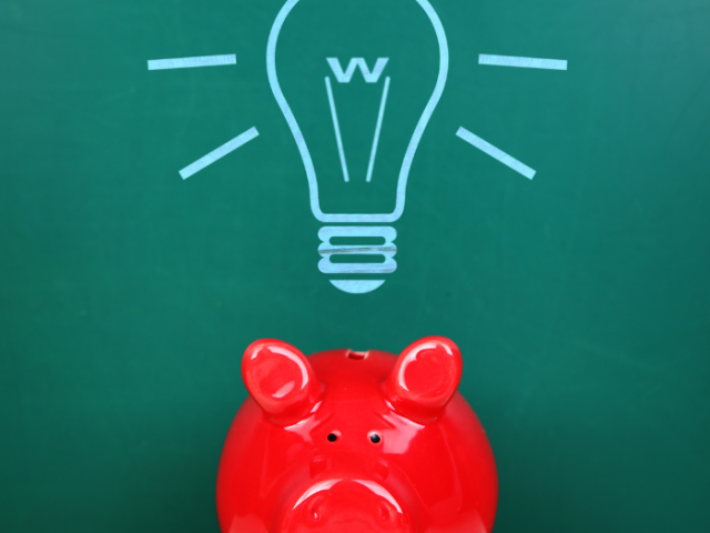red piggy bank with a drawing of a light bulb above it