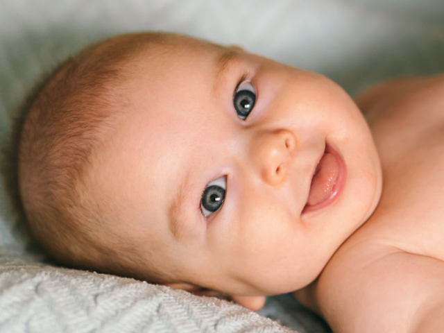 The image shows a small, smiling baby.