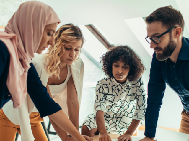 The image shows a diverse group of adults in discussion.