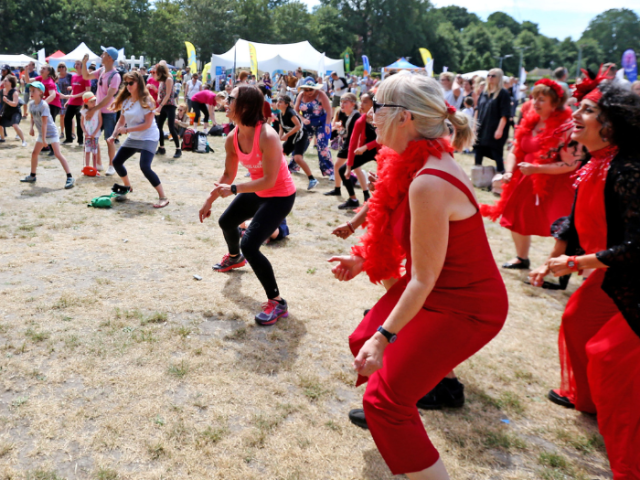 A group of women in red outfits taking part in an outdoor exercise class