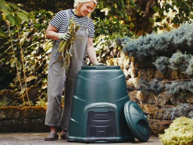 Photograph of woman putting garden waste in to a composter. 