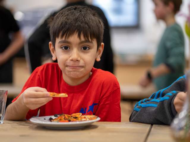 A HAF participant enjoying the pizza they made as part of the session with Brighton Table Tennis Club.