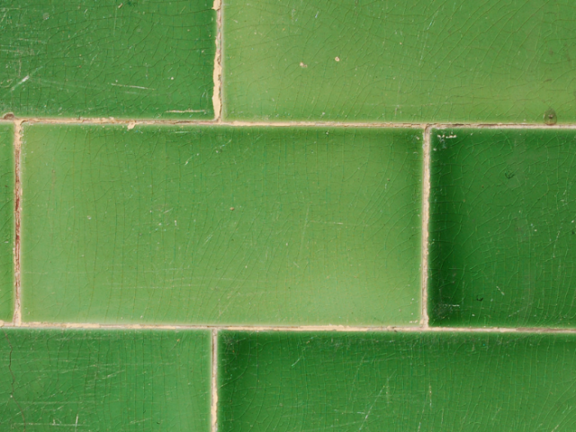 Rectangular green ceramic tiles laide horizontally with white grouting in between