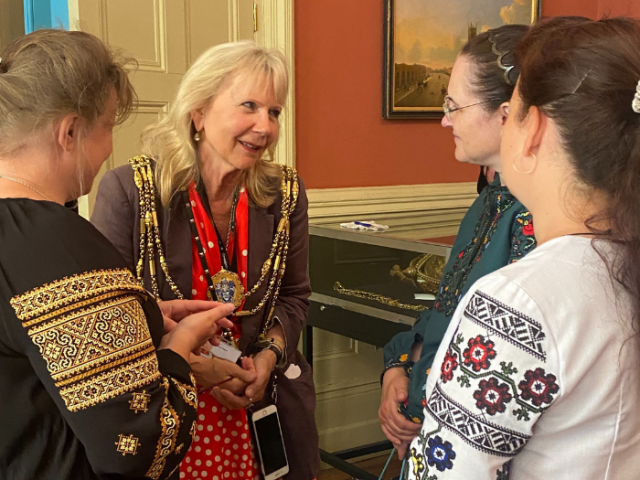 The Mayor of Brighton & Hove, Councillor Jackie O'Quinn talks to three women from Ukraine, which are wearing traditional embroidered shirts.