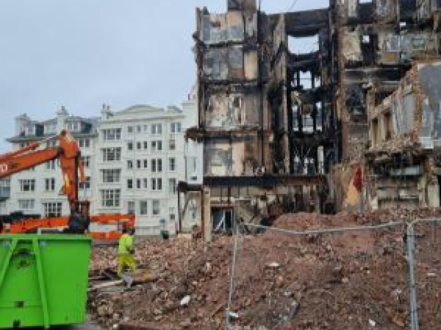 Image of the fire damaged remains of the Royal Albion Hotel next to rubble.