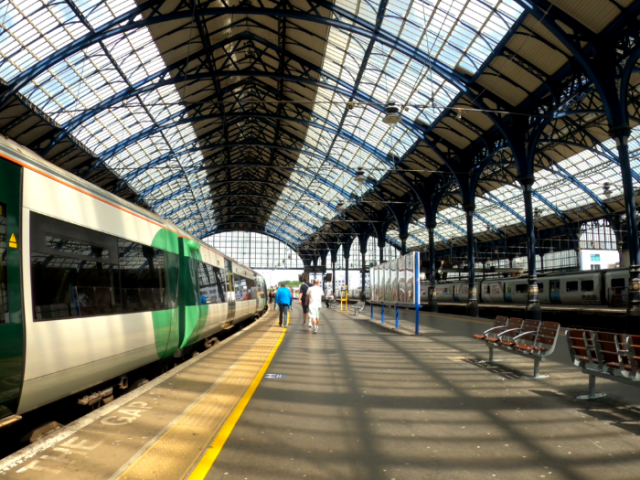 A picture of a train platform and train with passengers