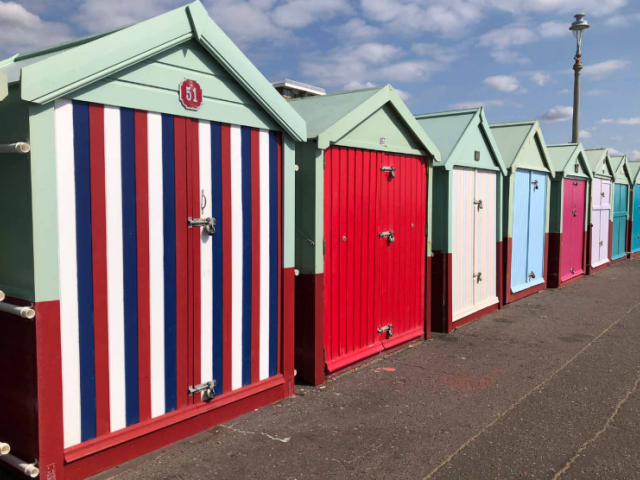Image showing beach huts on Hove seafront. Each one is a different colour. 