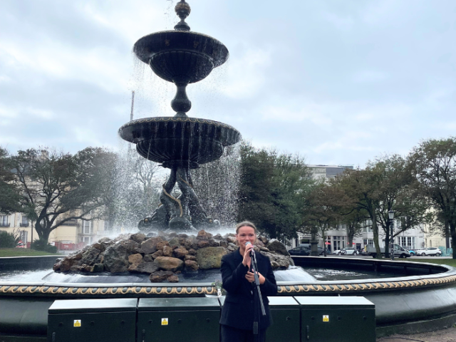 Photograph of council leader Bella Sankey in front of grand historic fountain.