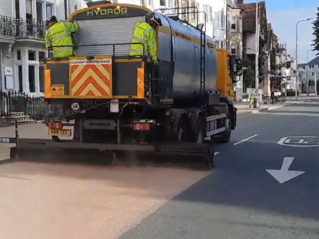 A lorry resurfacing a road