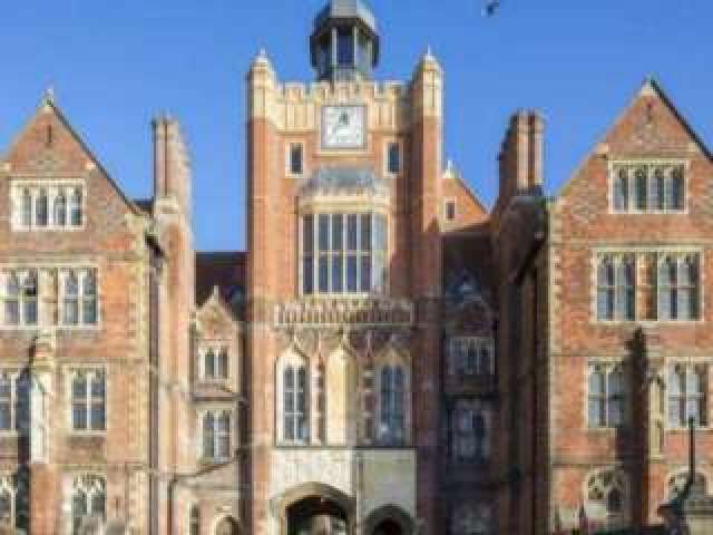he clock tower of Brighton College pictured on a sunny day against a clear blue sky.