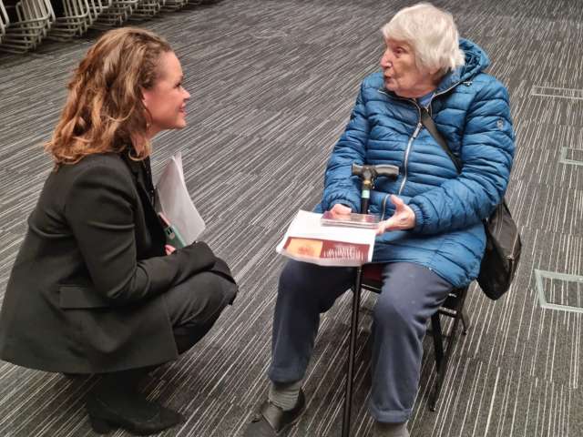 An image showing Council Leader Bella Sankey who is kneeling while talking to Holocaust survivor Ceska Abrahams who is sat down