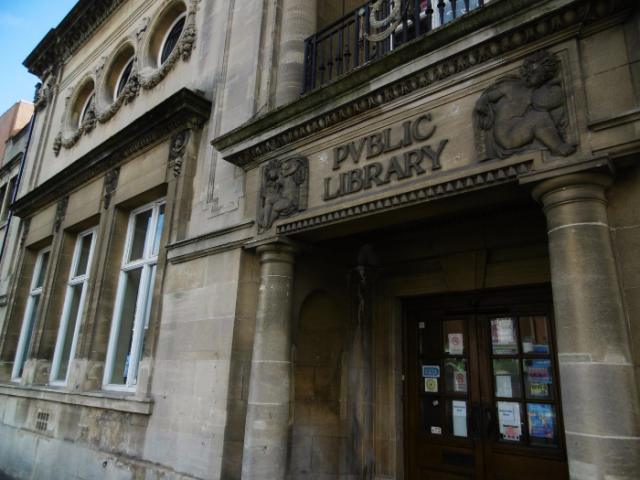 The image shows the front entrance of Hove Library. The text above the entrance reads 'Public Library'.