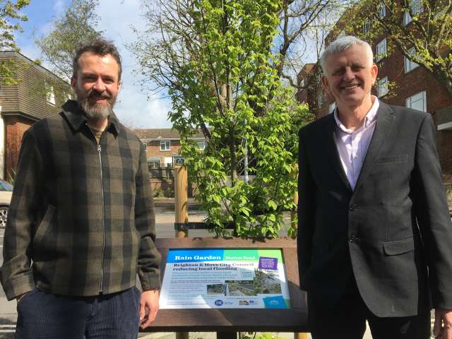 Councillors Rowkins and Muten with the new sign at the Norton Road rain garden, with a new street tree in the background