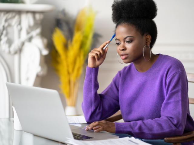 A young woman sitting at a table with a laptop