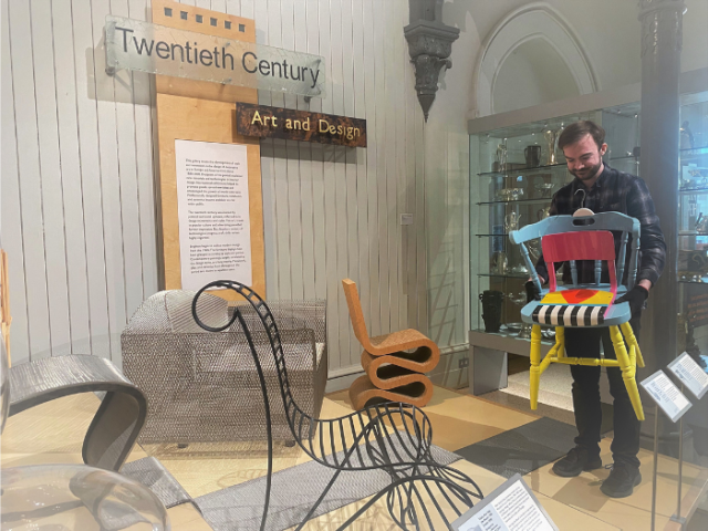 Conservation assistant moves items to prepare for roof project