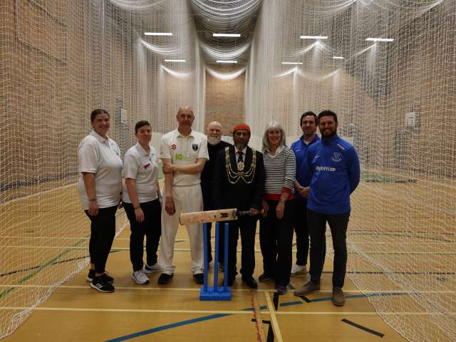 The Mayor holding a cricket bat and standing with representatives from Stanley Deason Leisure Centre, the Sussex Cricket Foundation, Rottingdean Cricket Club and council staff at the opening of the nets.