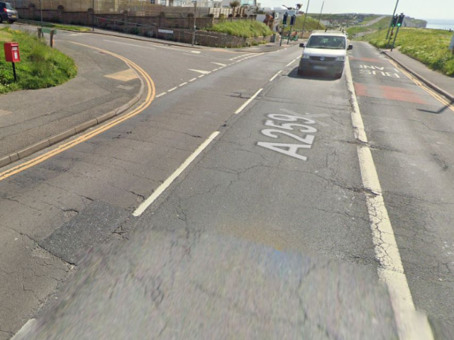 a picture of a damaged road with a van on it