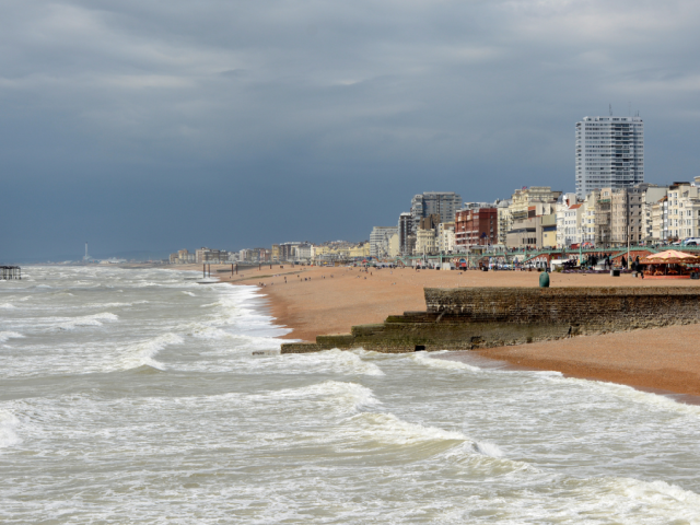 Brighton seafront showing the waves, beach and buildings behind