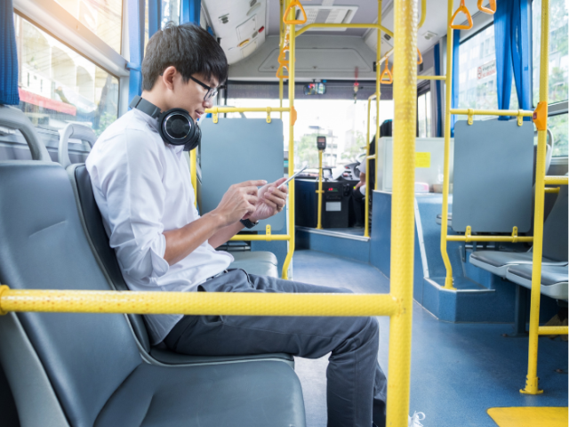A person sitting on a bus looking at their phone