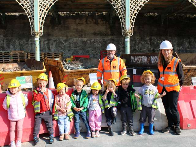 Children from Bloomsbury on the Beach stood in front of Madeira Terrace arches with staff from Mackley.