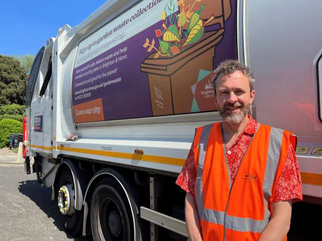 Councillor Tim Rowkins stood in front of a garden waste vehicle.
