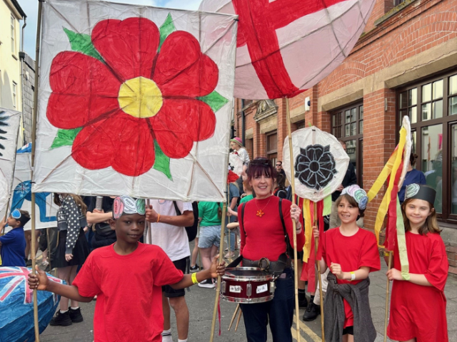 Children from Benfield Primary School carrying Red Rose banners, bringing the Women's Rugby World Cup 2025 to the Children's Parade