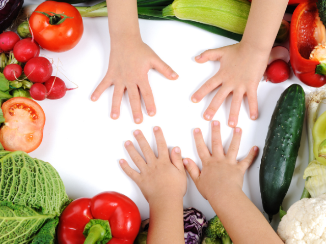 Children's hands with a selection of fresh vegetables