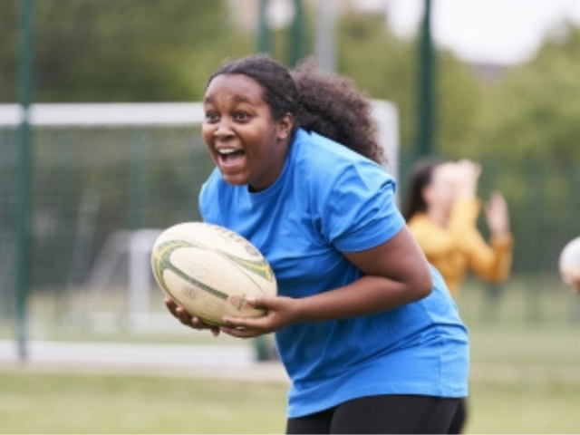 Pic of woman rugby player running with the ball