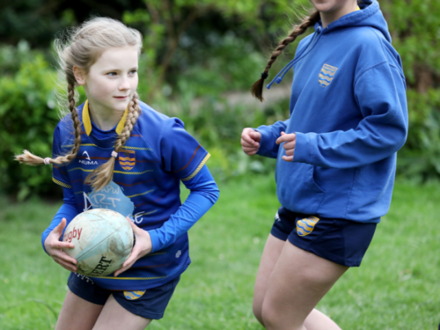 Picture of young rugby player running with the ball