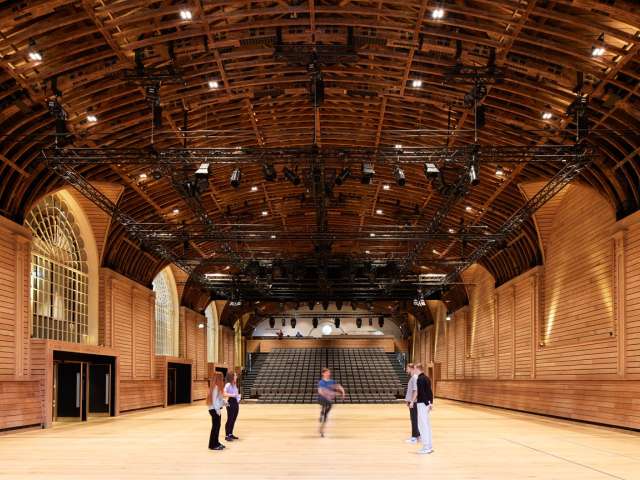 The renovated hall at the Corn Exchange, with a group of five people performing dance.