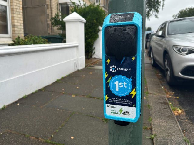 A picture of an electric vehicle chargepoint attached to a lamppost
