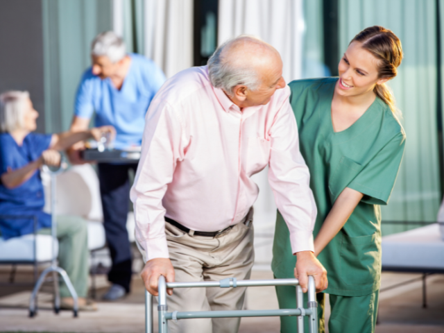 A person with a walker being helped by a nurse